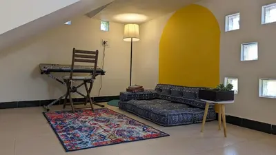 a living room with a couch and a chair at Yellow House Kotagiri in Kotagiri