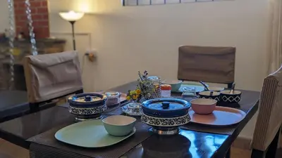 a table with blue and white bowls and plates on it at Yellow House Kotagiri in Kotagiri