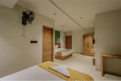 a room with a bedroom with a bed and a fan at Hotel Beverly Plaza Kozhikode in Kozhikode