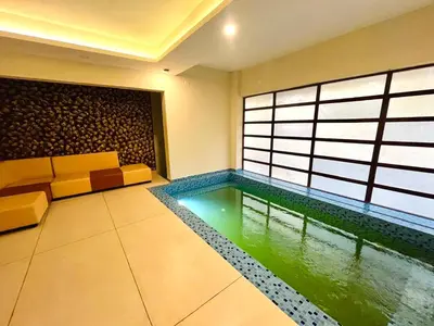 a living room with a pool in the middle of the room at Whitehouse homestay in Kannur