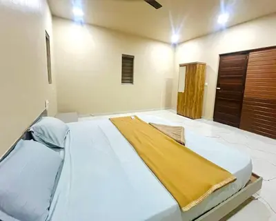 a bedroom with a large bed with a yellow blanket on it at Whitehouse homestay in Kannur