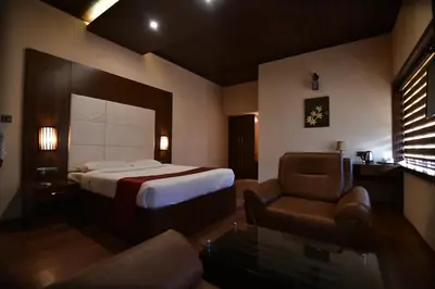 a hotel room with a bed and a chair at Garuda Luxury Bungalow in Trichūr