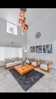 a living room with couches and tables and a clock at Resort Type Three Bed Room Villa in Trichūr