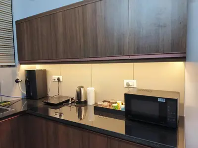 a kitchen with a counter top with a microwave at Posh 1 BHK Apt with Temple View in Guruvayur C1301 in Guruvāyūr