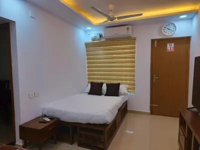 a bedroom with a bed and a clock on the wall at Posh 1 BHK Apt with Temple View in Guruvayur C1301 in Guruvāyūr