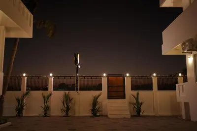 a white fence with lights on it at night at Golden Sands Cherai in Cherai Beach