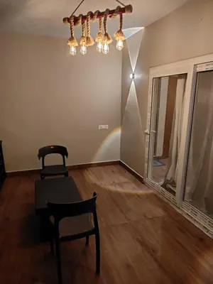 a room with a chair and a table and a chandelier at The Cozy Clouds Hill Stay in Napoklu