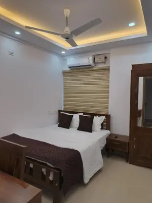 a bedroom with a bed with a ceiling fan at Posh 1 BHK Apt with Temple View in Guruvayur B1001 in Guruvāyūr