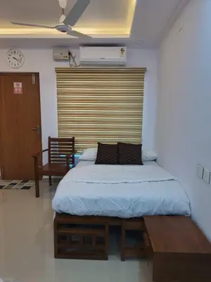 a bedroom with a bed with a wooden headboard at Posh 1 BHK Apt with Temple View in Guruvayur B1001 in Guruvāyūr