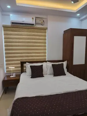 a bedroom with a large bed with a wooden headboard at Posh 1 BHK Apt with Temple View in Guruvayur B1001 in Guruvāyūr