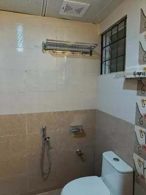 a bathroom with a toilet and a shower at Posh 1 BHK Apt with Temple View in Guruvayur B1001 in Guruvāyūr