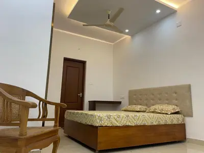 a bedroom with a bed and a chair and a ceiling at RoyalGiri Apartment near Rajagiri Hospital in Alwaye