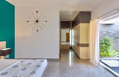 a bedroom with a large clock on the wall at Resort Type Three Bed Room Villa in Trichūr