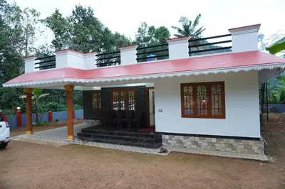 a small white house with a red roof at Mankulam Holidays Homestay in Viripara