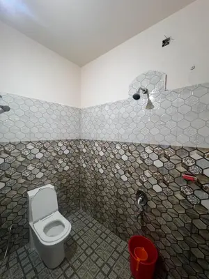 a bathroom with a toilet and a tiled wall at Mankulam Holidays Homestay in Viripara