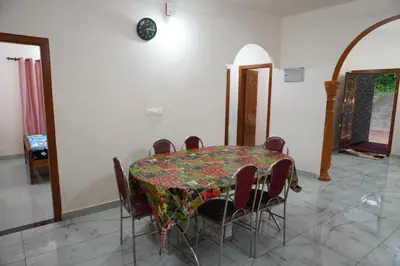 a dining room with a table and chairs at Mankulam Holidays Homestay in Viripara
