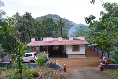 a small house with a car parked in front of it at Mankulam Holidays Homestay in Viripara