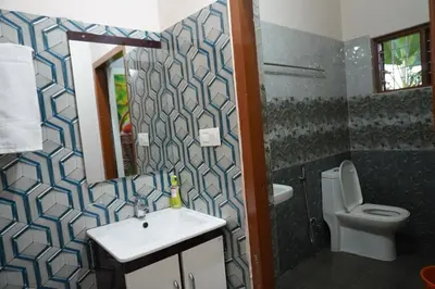 a bathroom with a sink and a toilet at Mankulam Holidays Homestay in Viripara