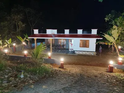 a house with lights in front of it at night at Mankulam Holidays Homestay in Viripara