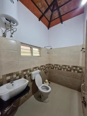 a bathroom with a toilet and a sink at MAYUR Home Stay in Suntikoppa