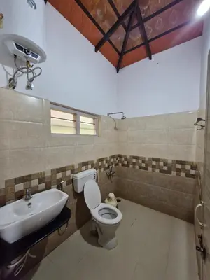 a bathroom with a toilet and a sink at MAYUR Home Stay in Suntikoppa