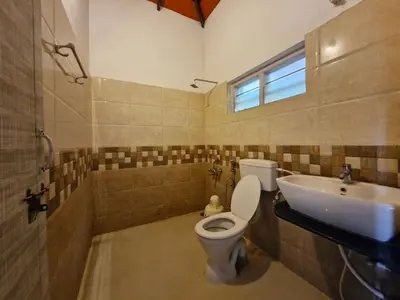a bathroom with a toilet and a sink at MAYUR Home Stay in Suntikoppa