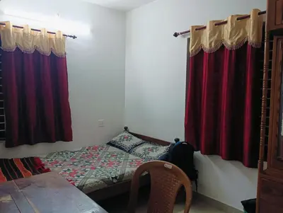 a bedroom with a bed and red curtains at Home in kannur in Kannur