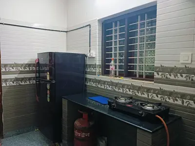 a kitchen with a stove and a refrigerator at Home in kannur in Kannur