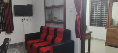 a living room with a chair and a television at Home in kannur in Kannur