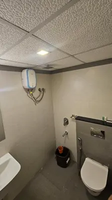 a bathroom with a toilet and a sink at Aaram Miraj Luxuria Apartment -1 in Wayanad