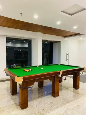 a pool table with a ball on top of it at Aaram Miraj Luxuria Apartment -1 in Wayanad