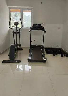 a room with two exercise bikes and a window at Aaram Miraj Luxuria Apartment -1 in Wayanad