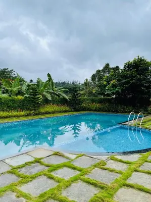 a swimming pool in the middle of a yard at Aaram Miraj Luxuria Apartment -1 in Wayanad