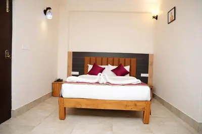 a bedroom with a bed with red pillows at Hotel Orchard Coorg in Virajpet