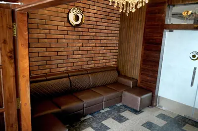 a bench in a room with a brick wall at Hotel Orchard Coorg in Virajpet