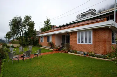 a yard with chairs and a house at Away From Home - 2 - Rooms In Ooty, Home Stay Ooty in Ooty