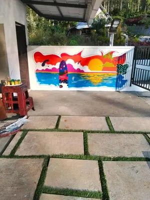 a wall with a colorful mural on it at Lilliput Haven Homestay in Sultan Bathery