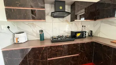 a kitchen with a counter with a toaster and a microwave at Leafy Mist Villa in Munnar