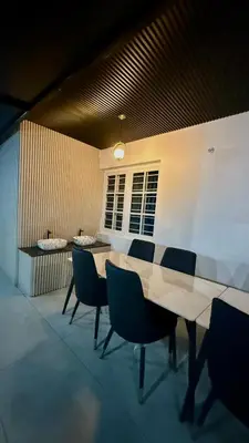 a room with a table and chairs and a window at Leafy Mist Villa in Munnar