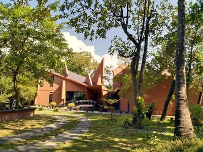 a building with trees in front of it at Green Haven Homestay in Kodungallūr