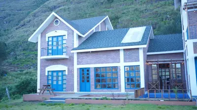 a house with blue doors and a mountain at Preserve Ooty in Ooty