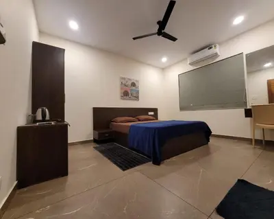 a bedroom with a bed and a flat screen tv at Aurora-The Pool Villa in Kozhikode