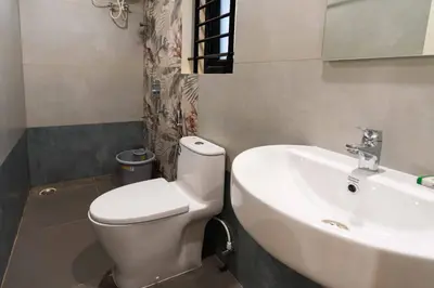a bathroom with a white toilet and a sink at The Paradise International Hotel in Coimbatore