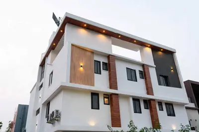 a white building with a wooden door at The Paradise International Hotel in Coimbatore
