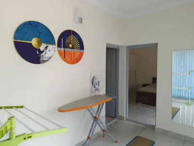 a room with a desk and two clocks on the wall at 7 Elysee Homestay - Safire - Premium 3BHK Family Flat in Trichūr