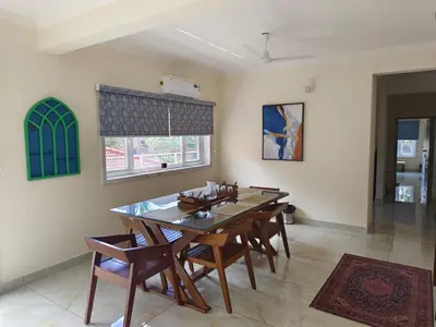 a dining room with a wooden table and chairs at 7 Elysee Homestay - Safire - Premium 3BHK Family Flat in Trichūr