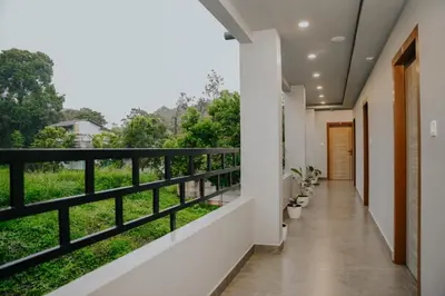 a corridor of a house with a balcony with trees at Saj Heritage in Kalpetta