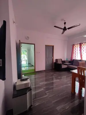 a living room with a couch and a ceiling fan at Stay Castle in Guruvāyūr