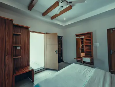 a bedroom with a bed and a ceiling fan at Azay Luxurious Apartment in Kalpetta