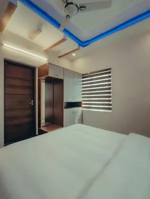 a bedroom with a large white bed and a closet at Azay Luxurious Apartment in Kalpetta